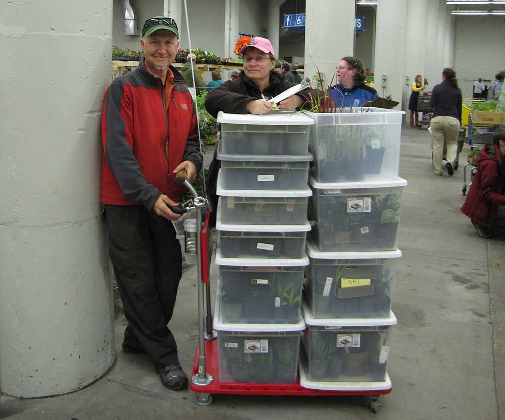 L-shaped base on wheels with 10 plastic bins with tops