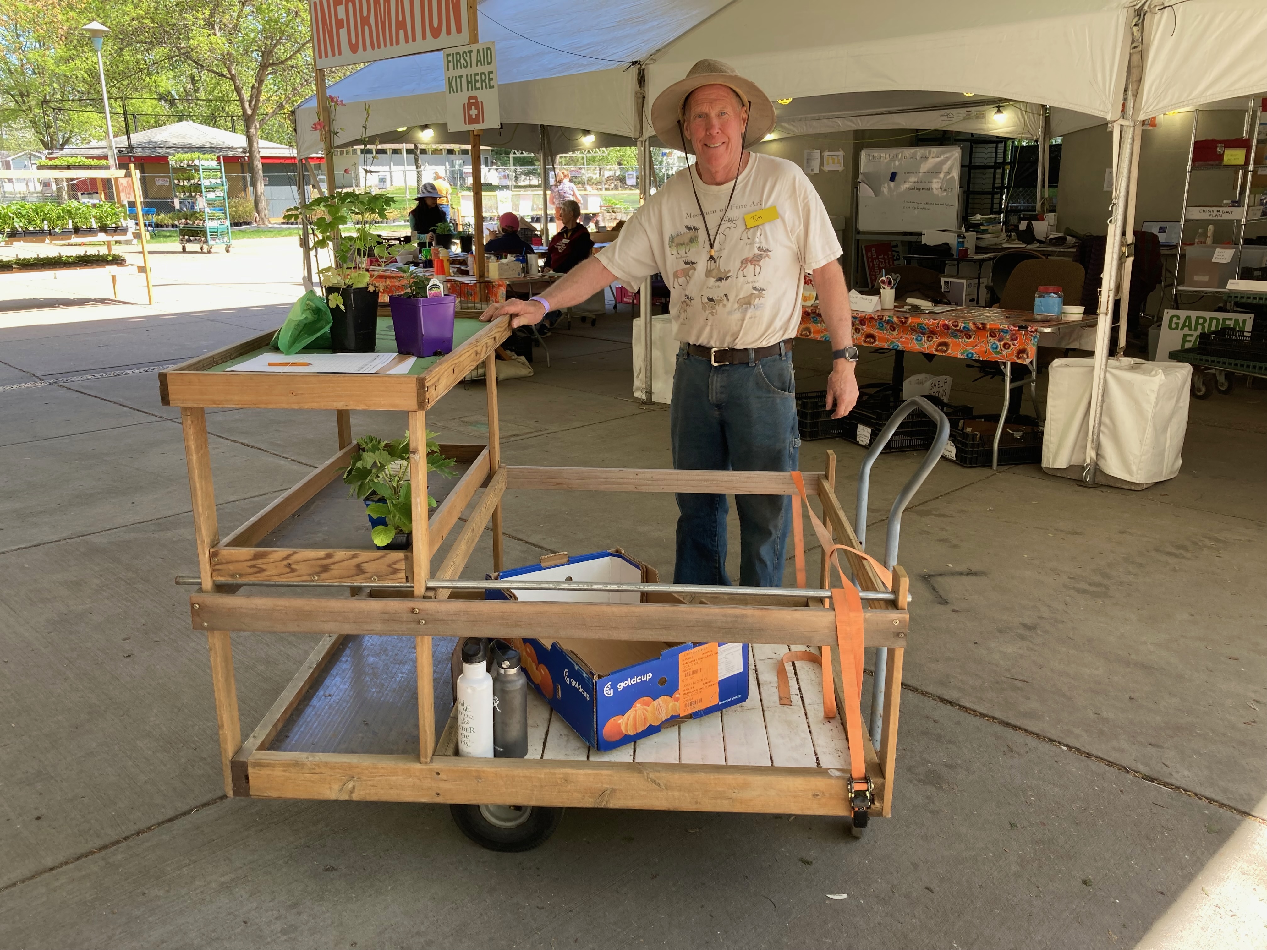 A man with a hand-made cart for carrying a huge number of plants