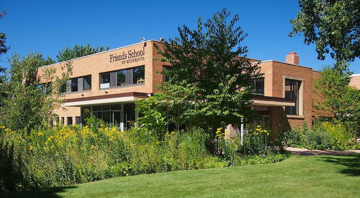 Friends School of Minnesota, a tan brick building with native plants in the foreground