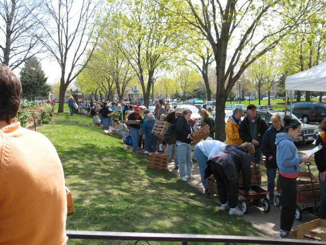 Lots of people standing in a line down a sidewalk