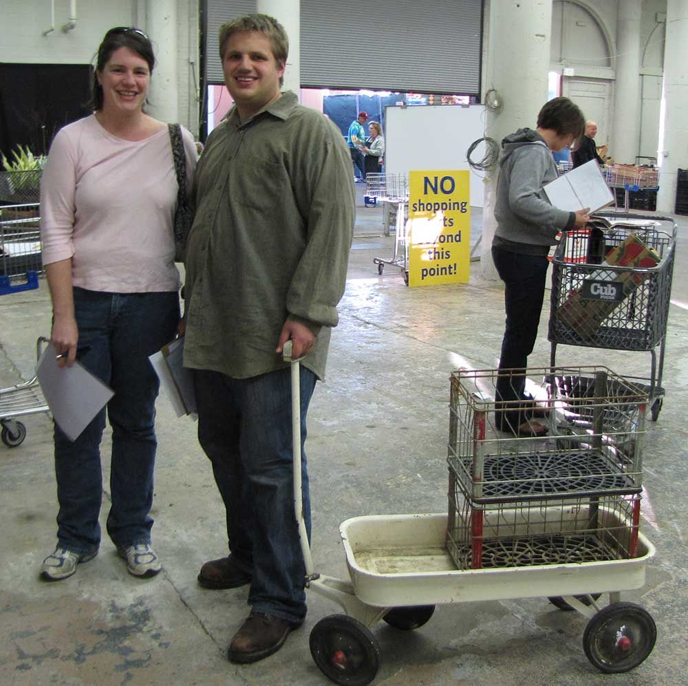 Two metal milk crates sitting in a small metal kids' wagon