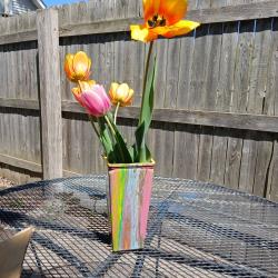 Multi-colored hand-painted vase with tulips on a table
