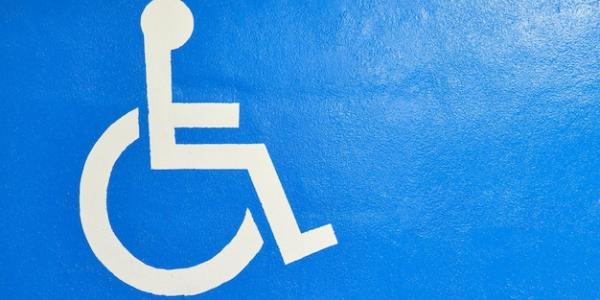 Blue wall with white wheelchair accessibility symbol painted on it